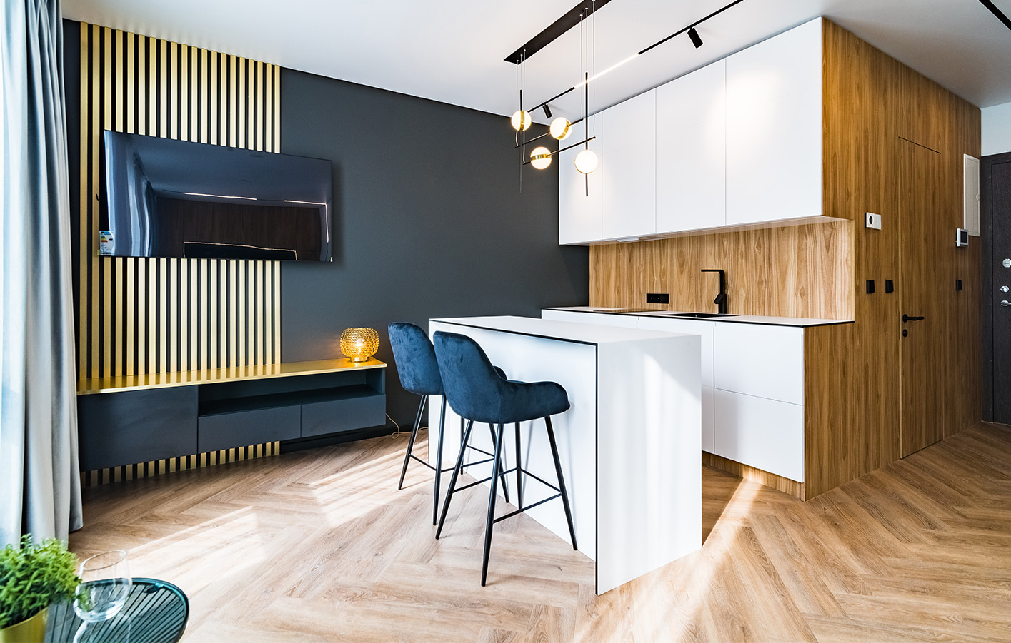 Moderner Wohnbereich mit Holz- und Wandpaneelen Moderner Wohnbereich mit Bar, weißer Küche und dekorativen Holzpaneelen.